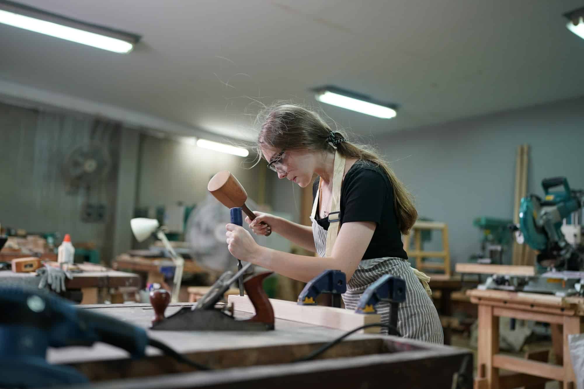 Small business of a young woman in furniture workshop background.